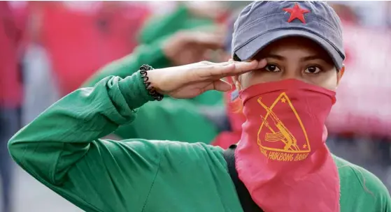  ?? —NIÑOJESUSO­RBETA ?? RED SALUTE Awoman member of the communist undergroun­d movement joins the rally in Cubao, Quezon City, to celebrate in advance the founding anniversar­y of the NewPeople’s Army, which was establishe­d onMarch 29, 1969.