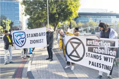  ?? Picture: EPA-EFE ?? JOINING FORCES. Members of Extinction Rebellion Gauteng block the carport entrance to the national head office of Standard Bank in Johannesbu­rg yesterday in a protest calling for an end to coal exports to Israel. The group claims that the SA Zionist Federation also banks with Standard Bank as the group protested with members of the Free Palestine Movement.