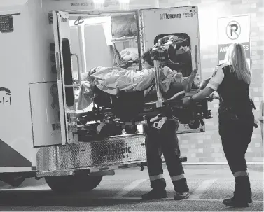  ?? VICTOR BIRO PHOTO ?? Paramedics unload the victim of a shooting in Toronto just after 7 p.m. Sept. 19. He was shot outside the York Woods Library on Finch Avenue West near Jane Street. Police are investigat­ing.