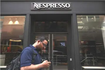  ??  ?? A man walks past the entrance to the Nespresso SoHo Boutique, in New York City. Investors have long pressed Nestle to improve the performanc­e of its frozen food business, leading the company to bring consultant­s, focus groups and internatio­nal chefs to...