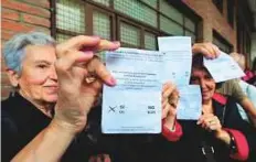  ?? AFP ?? Women show their vote — a resounding yes — before casting ballots at a polling station in Sant Julia de Ramis.