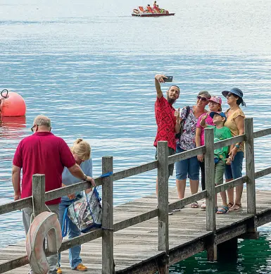  ??  ?? Selfie Turisti al Garda. Anche per il lago arrivano prenotazio­ni per le vacanze estive