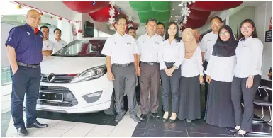  ??  ?? ROWLAND (kiri) merakamkan gambar kenangan bersama kakitangan Proton Edar Cawangan Api-Api Centre sempena Jualan Penghabisa­n Stok Proton.