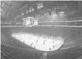  ?? MINAS PANAGIOTAK­IS/GETTY ?? The Canadiens and Flyers warm up in an empty Bell Centre on Thursday. The Quebec government requested the game be played without fans due to rising COVID-19 cases.