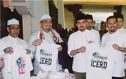  ?? [FOTO NIK ABDULLAH OMAR/BH] ?? Dr Asyraf bersama Ahli Jawatankua­sa PAS Pusat melihat baju-t ICERD di Kota Bharu, semalam.