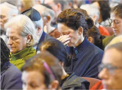  ?? AMY DAVIS/BALTIMORE SUN ?? Participan­ts in a service Sunday at Baltimore Hebrew Congregati­on observe a moment of silence in response to Saturday’s killings at a synagogue in Pittsburgh. Nearly 1,000 people attended; more came to a gathering Sunday afternoon at the Holocaust Memorial.