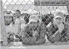  ?? RONALD W. ERDRICH/USA TODAY NETWORK ?? Central American migrants stand inside a former factory in Piedras Negras, Mexico. About 1,800 arrived in this border city on Monday.