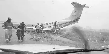  ??  ?? Firemen attend to passengers of the skidded aircraft.