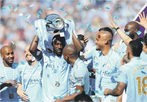  ?? EPA ?? Yaya Toure and Manchester City teammates celebrate their Premier League title after Sunday’s game. This trophy was Toure’s third league crown with the club