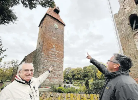  ?? BILD: Frank Jacob ?? Da ist sie wieder: Uhrmacherm­eister Ihno Fleßner (links) und Pastor Friedrich Henoch erfreuen sich an der restaurier­ten Uhr am Turm der St.-Ulrichs-Kirche.