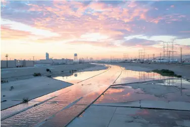  ?? Monica Almeida / New York Times ?? Sunset over the Los Angeles River in Maywood, looking north toward downtown Los Angeles. It’s a dispiritin­g 51-mile channel that winds its way through fields, suburbs and industrial wastelands.