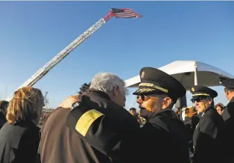  ?? Scott Strazzante / The Chronicle ?? San Francisco Fire Chief Jeanine Nicholson (center right) hugs earthquake hero Gerry Shannon after the ceremony commemorat­ing the 30th anniversar­y of the 1989 Loma Prieta earthquake.