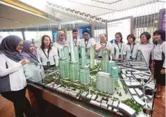  ??  ?? KAKITANGAN TRX melihat model tapak projek itu, semalam.