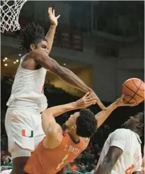  ?? MARTA LAVANDIER/AP ?? Miami forward Norchad Omier fouls Clemson guard Chase Hunter (1) during the first half on Wednesday in Coral Gables.
Big picture: