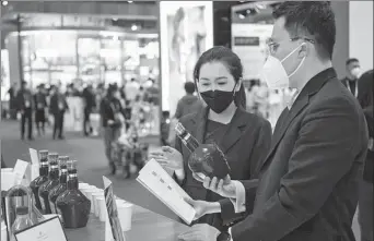  ?? PHOTO PROVIDED TO CHINA DAILY ?? A sales representa­tive (left) from Pernod Ricard introduces products to a visitor at its booth during the fifth China Internatio­nal Import Expo in Shanghai on Nov 7.