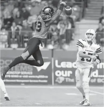  ??  ?? B.C. Lions’ Chandler Fenner blocks a pass by Toronto Argonauts’ Ricky Ray.