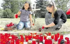  ?? Foto: Iveta Lhotská, MAFRA ?? Svíčky pro zastřelené­ho Dívky zapalují svíčky u teprve dva dny starého památníčku na místě chomutovsk­é tragédie.