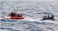  ?? U.S. COAST GUARD ?? U.S. Coast Guard personnel arrive to assist Cuban migrants on a makeshift vessel in the Florida Straits in January 2016.