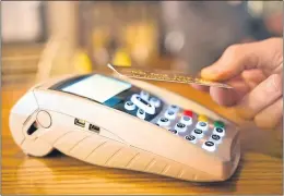  ??  ?? Paying with a simple swipe – but contactles­s fraud is on the rise