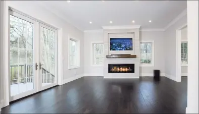  ??  ?? The home’s interiors are decidedly modern and bright, with white-oak hardwood flooring, lots of sunny exposures, and thoughtful details, like the built-in nook for a digital display above the gas-powered fireplace in the family room.