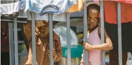  ?? ODELYN JOSEPH/AP ?? Children look through a fence at a shelter for families displaced by gang violence in Port-auPrince, Haiti, on March 13.