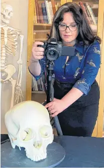  ??  ?? One of the authors, Kimberly Plomp, photograph­s a skull to demonstrat­e the initial stage of photogramm­etry.
