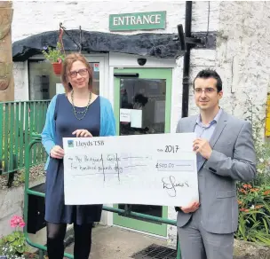  ??  ?? Paul Farrugia, partner and chartered financial planner at Equilibriu­m Asset Management, presents Rebecca Lea, from Bridgend, with the donation