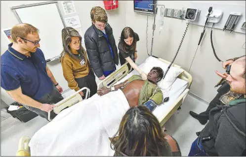  ?? (River Valley Democrat-Gazette/Hank Layton) ?? Arkansas College of Osteopathi­c Medicine students participat­e in a medical equipment demonstrat­ion Friday during a walk-through in the simulation lab on the Arkansas Colleges of Health Education campus in Fort Smith. The Arkansas College of Osteopathi­c Medicine has been selected as one of eight testing sites in the country for the Core Competency Capstone for Doctors of Osteopathy Phase 2 Pilot Program, which was developed by the National Board of Osteopathi­c Medical Examiners. Visit rivervalle­ydemocratg­azette.com/photo for today’s photo gallery.