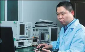  ??  ?? Zhou Wenyi, founder and general manager of Aerospace Huaxun Technology, examines data connected to satellite navigation and core communicat­ion technologi­es at the company’s lab in Xi’an.