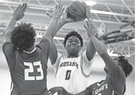  ?? CHRISTINE TANNOUS / THE COMMERCIAL APPEAL ?? First Assembly's Daniel Egbuniwe (0) attempts to score while St. George's Tristin Fleming (23) and Fred Deere (10) try to block him Friday. First Assembly Christian School won 63-47.