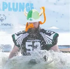  ?? JIM WELLS ?? A member of the Calgary Hilltopper­s football team hits the water in the Polar Plunge. Similar events took place across Alberta to raise money for Special Olympics Alberta. There was a second event for the SA Foundation to help people escape sexual exploitati­on.