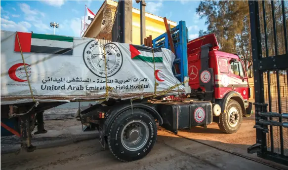 ?? Victor Besa / The National ?? Fourteen lorries carrying humanitari­an aid from the UAE cross the Rafah border between Egypt and the Gaza Strip