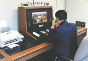  ?? YONHAP VIA AP ?? A South Korean government official checks the direct communicat­ions hotline to talk with the North Korean side Wednesday at the border village of Panmunjom in Paju, South Korea.