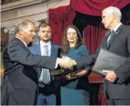  ?? THE ASSOCIATED PRESS ?? Vice President Mike Pence, right, shakes hands with Sen. Doug Jones, D-Ala., after administer­ing the Senate oath of office to Jones during a mock swearing-in ceremony in the Old Senate Chamber on Wednesday. They are joined by Jones’ wife, Louise,...