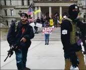  ?? PAUL SANCYA FILE — THE ASSOCIATED PRESS ?? Protesters carry rifles near the steps of the Michigan State Capitol building in Lansing, Mich., on April 15. A plot to kidnap Michigan’s governor has put a focus on the security of governors who have faced protests.