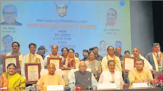  ?? DEEPAK GUPTA/HT PHOTO ?? Governor Ram Naik, chief minister Yogi Adityanath and deputy CM Dinesh Sharma with the teachers who were felicitate­d at Lok Bhawan in ▪Lucknow on Wednesday.