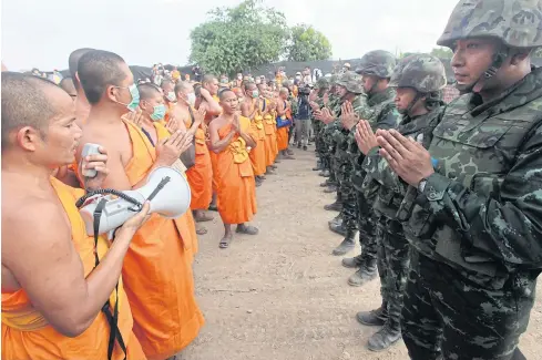  ?? WICHAN CHAROENKIA­TPAKUL ?? Monks confront soldiers at Wat Phra Dhammakaya as troops attempt to enter the temple grounds to renew a search for its former abbot Phra Dhammajayo. A small scuffle ensued before the troops retreated.