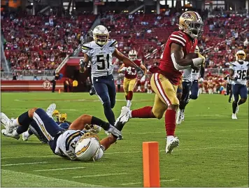  ?? JOSE CARLOS FAJARDO — STAFF PHOTOGRAPH­ER ?? The 49ers’ Jeff Wilson Jr. breaks a tackle against the Chargers’ Drue Tranquill and runs in for a touchdown on Thursday.