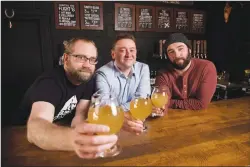  ?? Canadian Press photo ?? Barn Hammer Brewing Company Head Brewer Brian Westcott, left to right, University of Winnipeg Associate Professor and Chair of Classics Dr. Matt Gibbs, and Barn Hammer Brewing Company Owner Tyler Birch pose for a photo last week after they teamed up to...