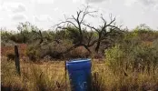  ?? MICHAEL GONZALEZ / AP ?? A water station for immigrants containing sealed jugs of fresh water sits along a fence line near a roadway in rural Jim Hogg County, Texas, last month.