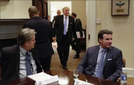  ?? ASSOCIATED PRESS FILE ?? President Donald Trump smiles as he walks in from the Oval Office of the White House in Washington, to host breakfast with business leaders in the Roosevelt Room. Sitting at the table are then-White House senior adviser Steve Bannon, left, and Kevin Plank, founder, CEO and Chairman of Under Armour. Trump returned fire with both barrels Wednesday against criticism leveled at him in a new book that says he never expected — or wanted — to win the White House, his victory left his wife in tears and a senior adviser thought his son’s contact with a Russian lawyer during the campaign was “treasonous.”