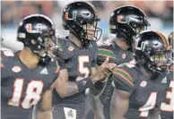  ?? MICHAEL LAUGHLIN/SUN SENTINEL ?? Miami QB N’Kosi Perry, center, breaks from the huddle as the Hurricanes starter against North Carolina. This week Perry, a freshman, gets his first taste of the Miami-Florida State rivalry.