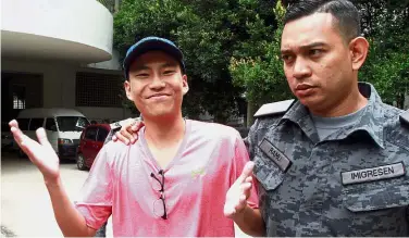  ??  ?? An Immigratio­n officer leading Yun-soung away after he was acquitted and discharged by the Seremban High Court for allegedly traffickin­g in cannabis at his college about a year ago. Cleared of wrongdoing: