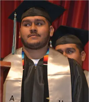  ?? ?? Miguel Machuca waits for his turn to grab his diploma during the Harmony Magnet Academy graduation ceremony on Friday at the Buck Shaffer Theater at Portervill­e Memorial Auditorium.