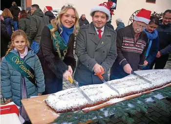  ?? MICHAEL GRÜBNER (5) ?? Weinprinze­ssin Emma, Bürgermeis­ter Dirk Schütze (SPD) und Ortschafts­bürgermeis­ter Dieter Kranich (parteilos) schnitten den Riesenstol­len an.