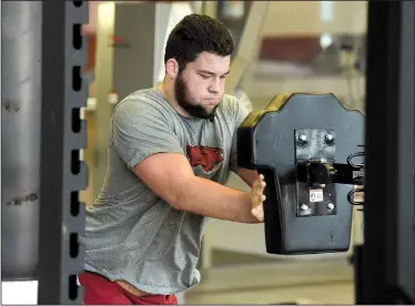  ?? NWA Democrat-Gazette file photo ?? Arkansas Razorbacks offensive lineman Shane Clenin, one of nine players who enrolled early for spring classes, works out in the weight room at the Fred W. Smith Center in Fayettevil­le. The Razorbacks went through an eight-week winter training program,...