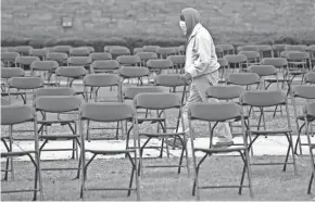  ?? MIKE DE SISTI/MILWAUKEE JOURNAL SENTINEL ?? Johnnie Hodges walks through an array of empty chairs at the newly created Milwaukee COVID-19 Memorial.