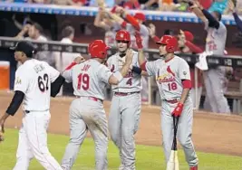  ?? ROB FOLDY/GETTY IMAGES ?? St. Louis’ Jon Jay, Yadier Molina (4) and Carlos Martinez (18) celebrate after tying the game against Miami in the fourth inning Tuesday.