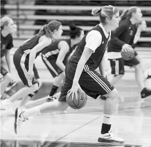  ?? BRUCE EDWARDS/ EDMONTON JOURNAL ?? University of Alberta Pandas’ Saskia VanGinhove­n, foreground, dribbles during a team practice on Thursday.