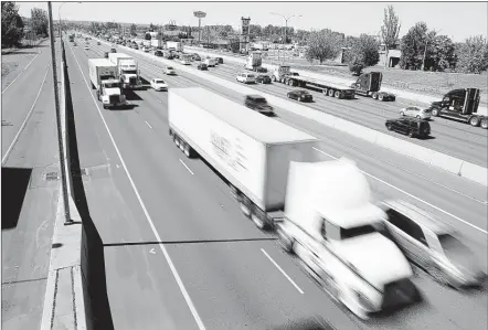  ?? TED S. WARREN/ASSOCIATED PRESS ?? Truck and automobile traffic mix on Interstate 5, headed north through Fife, Wash., near the Port of Tacoma. The federal government proposed a new regulation Friday that would require new vehicles weighing more than 26,000 pounds be outfitted with a...